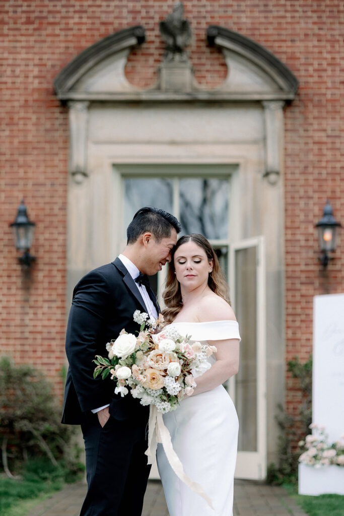 Bride and groom standing close in front of doorway.