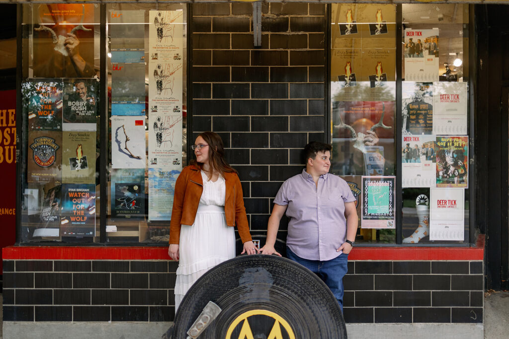Two people standing outside a record store.