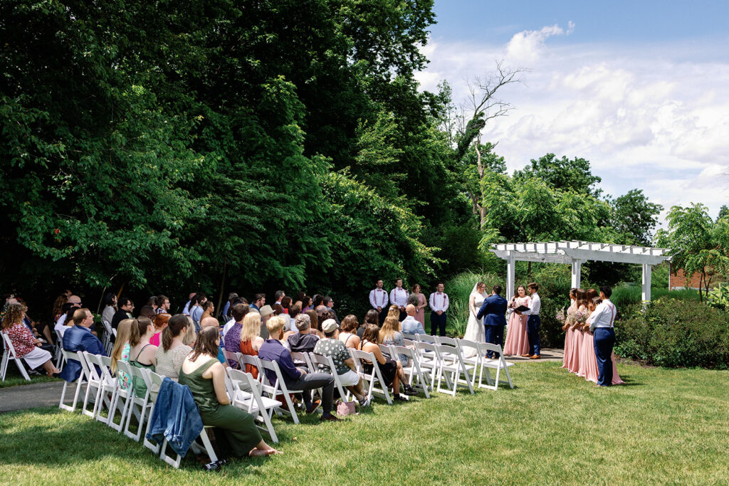 Couple surrounded by loved ones at alter at The Estate at Sunset Farms