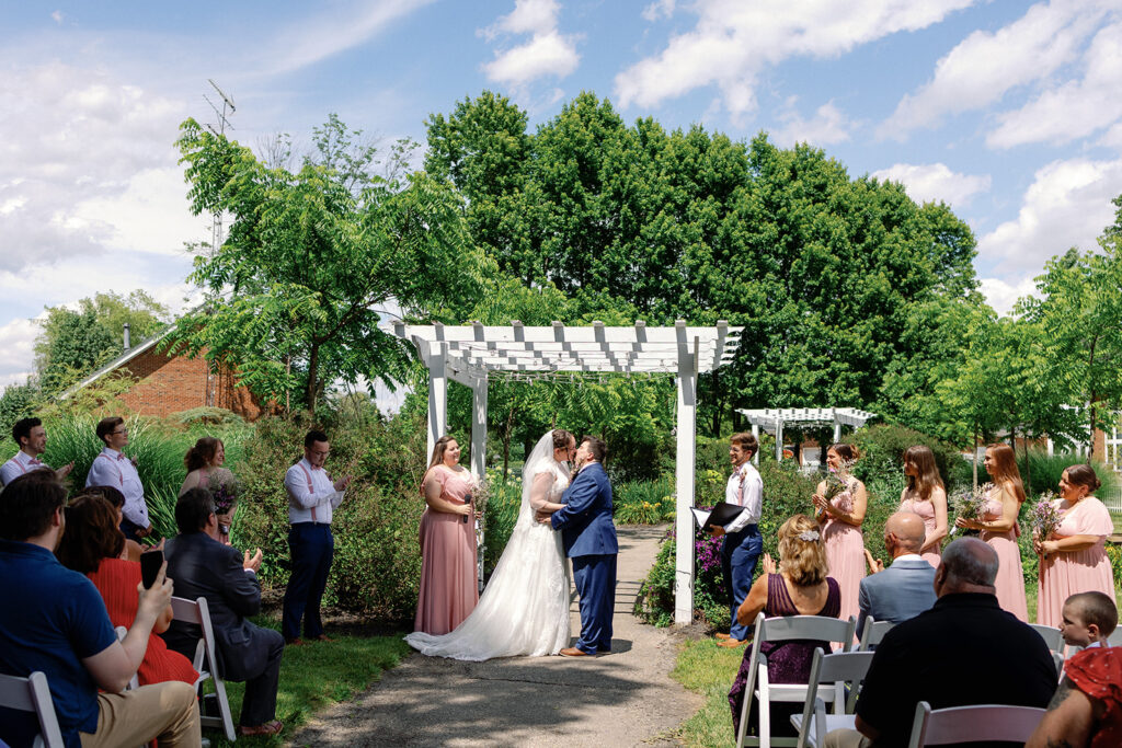 Couple surrounded by loved ones at alter at The Estate at Sunset Farms