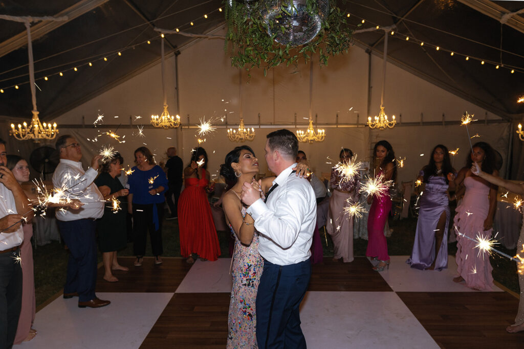 Couple dancing on the dance floor surrounded by guest.