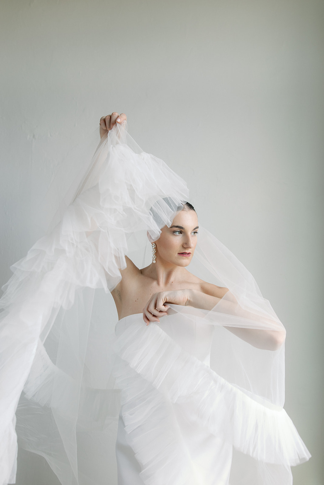 A bride showing off her veil during bridal portraits